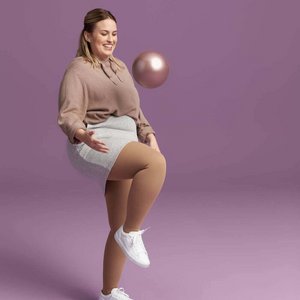 Das Bild zeigt eine Frau, die mit einem Ball spielt. Sie trägt VenoTrain Delight Kompressionsstrümpfe an ihren Beinen.